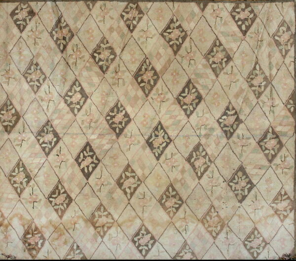 Muted beige rug with a diamond trellis pattern containing pink and green floral designs.