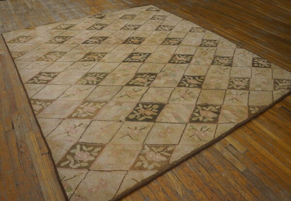 Low pile beige hooked rug with brown and pink floral diamond pattern on wood flooring.
