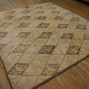 Muted beige rug features a checkerboard floral pattern in brown, pink, and green on wood planks.