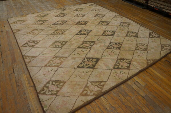 Muted beige rug features a checkerboard floral pattern in brown, pink, and green on wood planks.