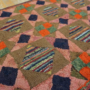 High-texture rug featuring colorful geometric diamond patterns in brown, pink, navy, orange, and striped patches.
