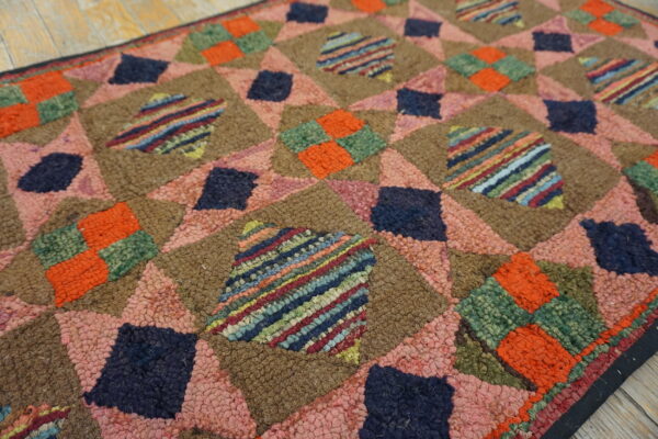 High-texture rug featuring colorful geometric diamond patterns in brown, pink, navy, orange, and striped patches.