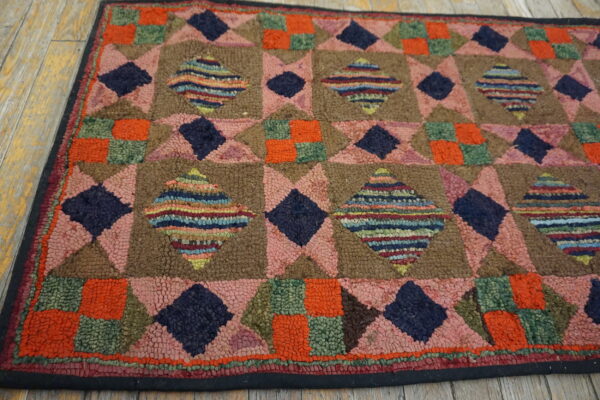 Patchwork geometric rug with pink, brown, navy, and orange textures on light wooden floorboards.