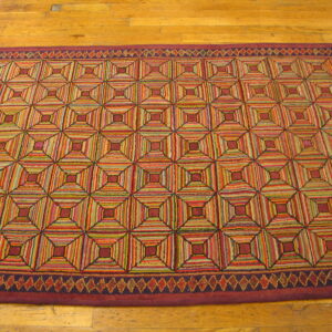 Multicolored hooked rug runner featuring a stacked geometric square pattern on a wood floor.