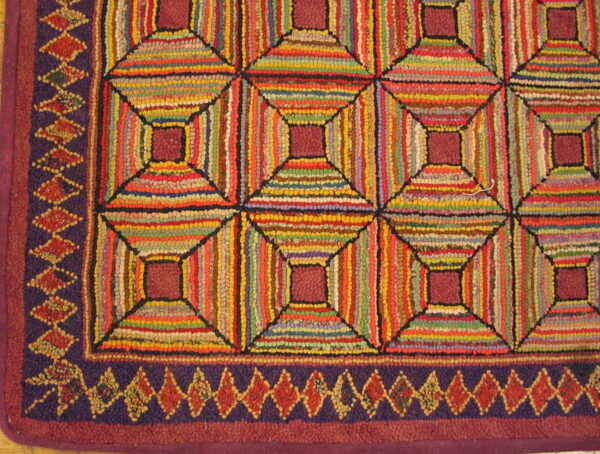 Highly textured, multicolored hooked rug with a geometric pattern of concentric squares and a purple diamond border.