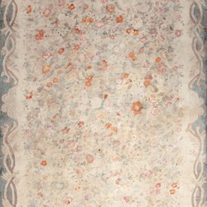 Light beige rug featuring dense pink and terracotta floral motifs and a dusty blue scrolling botanical border.