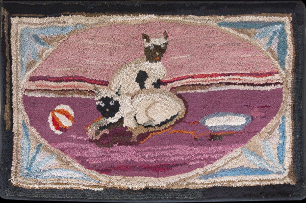 Shaggy, rustic rug depicting two cats within a pink and purple oval, framed by blue and black borders.