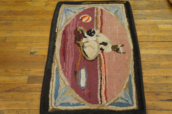 High-pile hooked rug featuring a bird motif and bold oval pattern in pinks and blues on distressed wood flooring.