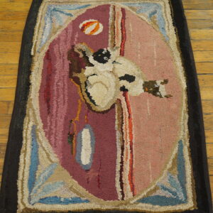 Coarse textured rug with a central abstract white figure on a split maroon and pink ground over wood flooring.