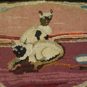 Hooked rug detail featuring two cream lambs with dark faces on a pink and purple textured field.