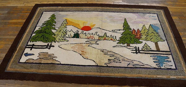 Textured rug with a scenic landscape pattern of snow, green trees, a sun, and thick brown borders on wood flooring.