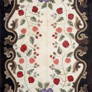 Cream rug with red and purple floral pattern and a bold, dark brown scrolled border.