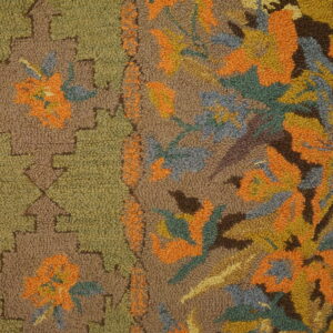 Brown, green, and orange hooked pile rug featuring a dense floral pattern next to a stepped border.