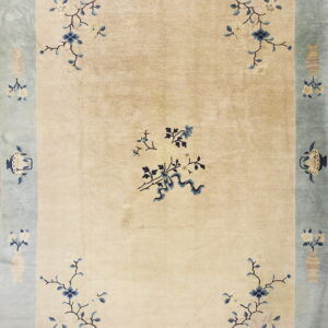 Cream rug with blue floral sprays and a wide, pale blue border patterned with beige vases and lanterns.
