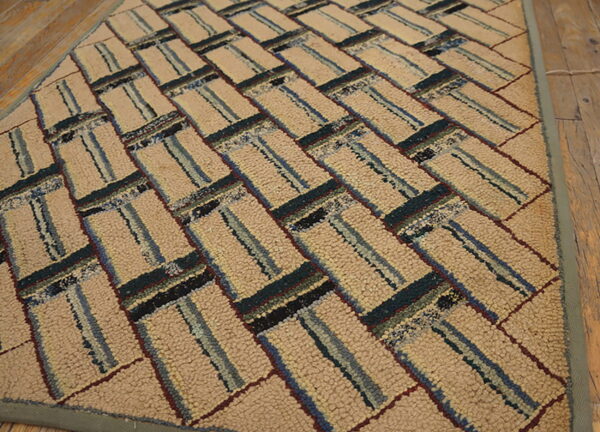 Chunky hooked rug in beige and multi-colored stripes forms a diagonal pattern on a wood floor.