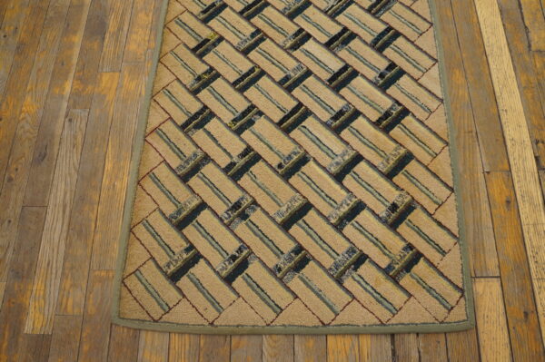Textured beige rug with a diagonal striped block pattern in blue, green, and maroon rests on wood flooring.
