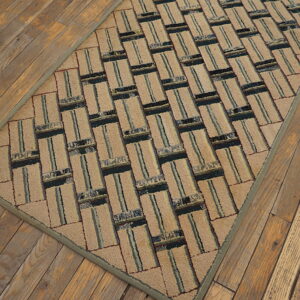 Textured beige runner rug with a striped, rectangular geometric pattern sits atop rustic plank flooring.