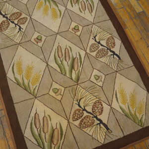Tan rug with a geometric grid pattern showcasing pinecones, cattails, and wheat on distressed wood flooring.