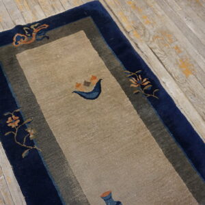 Beige runner with wide navy borders and sparse orange and blue decorative motifs on weathered wood floors.