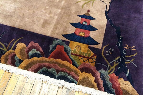Sculpted high-pile rug displaying a pagoda and multicolored mountains rests on light wood floors.