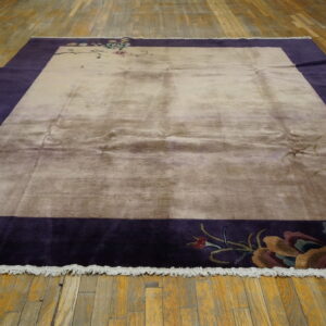 Beige and purple rectangular rug with Asian pagoda and floral motifs lying on rustic wood floorboards.