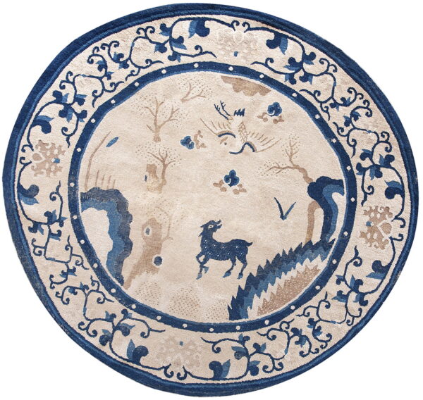 Circular rug in beige, deep blue, and tan with a stylized scenic pattern and ornate floral borders.