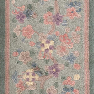 Muted green runner rug featuring an all-over pattern of pink, lavender, and yellow flowers.