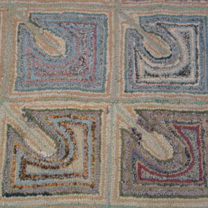 Textured low-pile rug with geometric block design in pastel blue, pink, tan, and lavender colors.