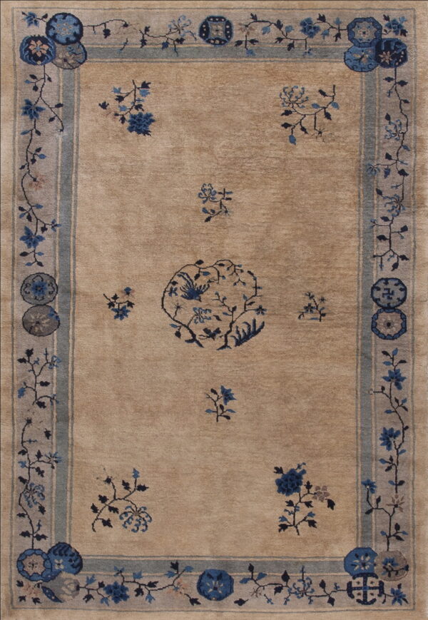Muted tan rug displaying blue floral motifs, a central vine pattern, and gray-blue striped borders.