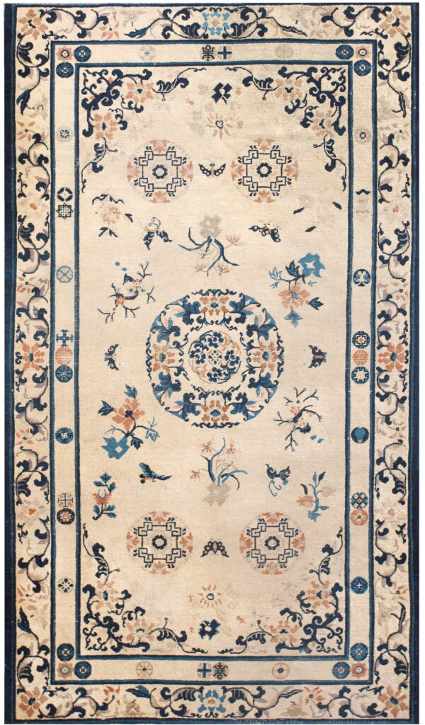 Cream rug with scattered blue and peach floral designs, a central medallion, and a thick blue border.