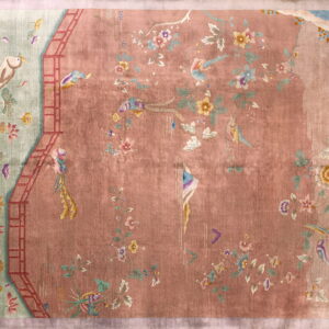 Muted dusty rose rug with a scenic pattern featuring birds, florals, and a mint green side border.