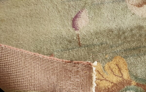 Red knotted antique 1920s room size wool rectangle chinese - art deco rug 4 Detail view of a rug showing sage green pile, mauve pattern, and tightly woven pink selvedge backing.