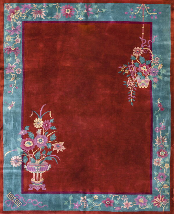 Burgundy rug with a turquoise floral border and detailed pink and lavender floral vase patterns.