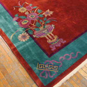 High-pile rug featuring a red field, colorful floral designs, and a wide turquoise border on wood flooring.