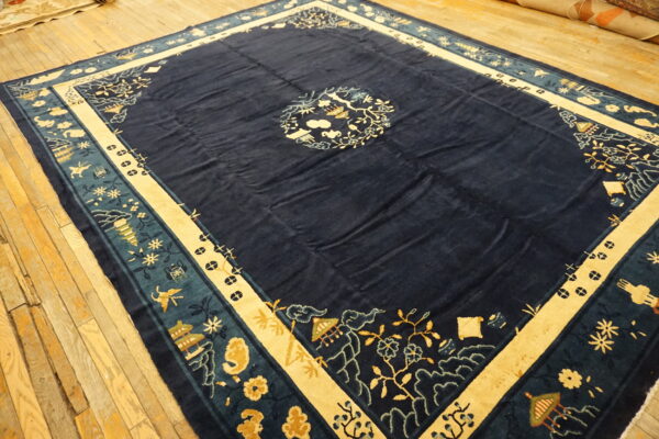 Large navy blue rug with a central medallion and complex borders in cream, teal, and gold on wood floor.