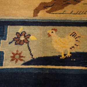 Navy blue and light blue rug border featuring a yellow chicken and floral patterns on a beige background.