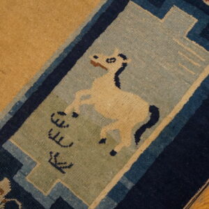 Tan rug featuring a cream horse and symbols in a blue and sage decorative border on wood floor.