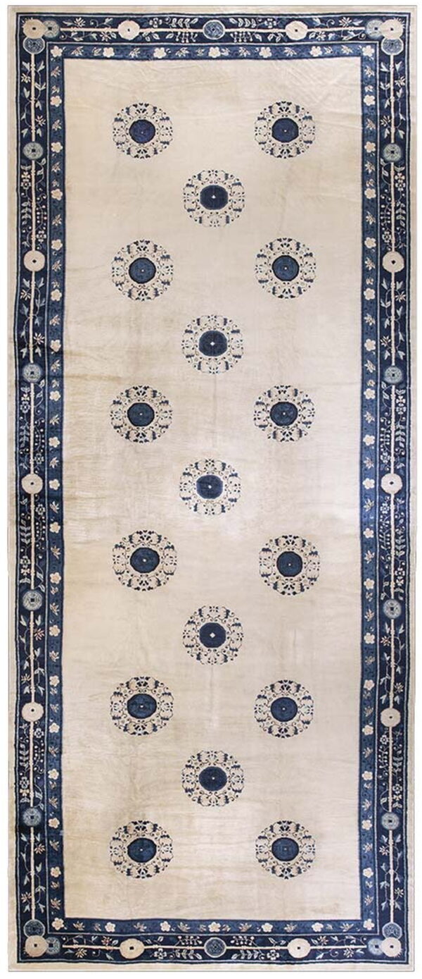 Long cream rug featuring repeating navy medallions and wide intricate blue and white borders.