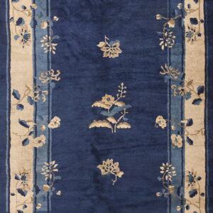 Navy blue rug with beige and pale blue floral sprays and a wide, layered tan outer border.