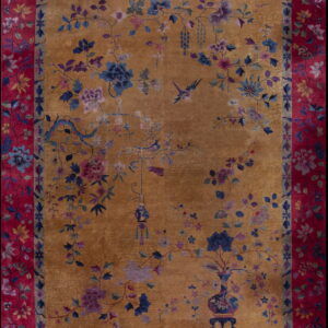 Traditional amber rug with blue and purple botanical motifs bordered by wide, bright crimson floral bands.