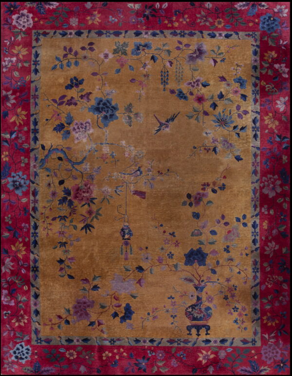 Traditional amber rug with blue and purple botanical motifs bordered by wide, bright crimson floral bands.