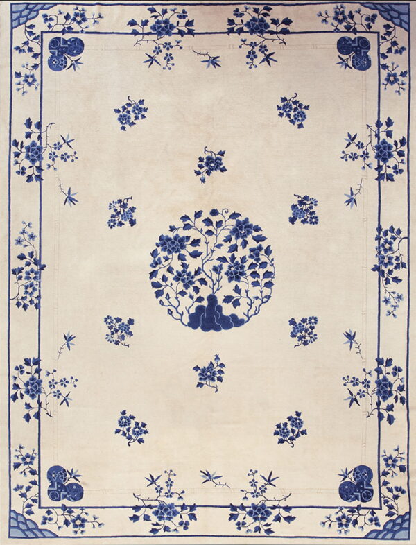Blue and white rug with a central floral tree medallion and detailed floral borders.