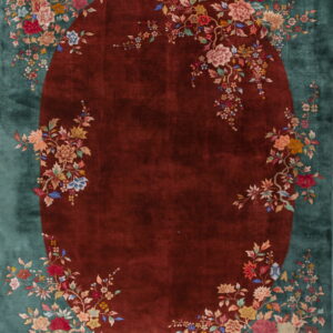 Plush teal rug with a central maroon oval field framed by colorful floral vines.