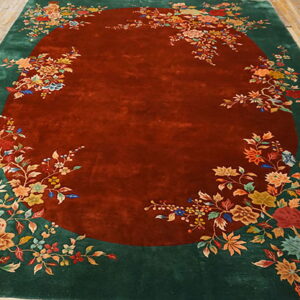 Ornate floral rug with a deep reddish-brown central field surrounded by a wide green border.