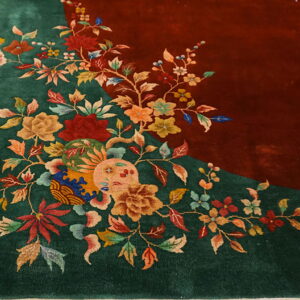 High-pile green and red rug featuring detailed vines, leaves, and large multicolored blossoms on wood planks.