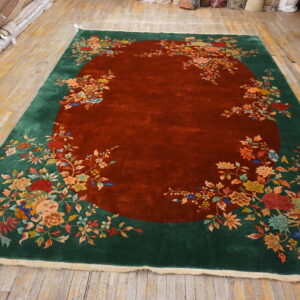 Large high-pile rug with a rust red center and dense multicolored floral patterns on a dark green border.