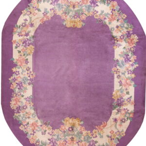 Oval purple rug featuring a floral garland border in cream, pink, yellow, and blue colors.