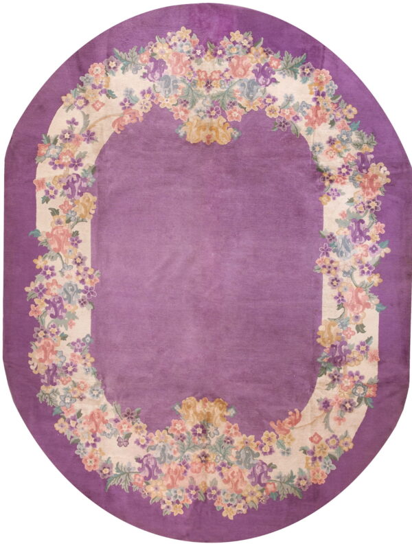 Oval purple rug featuring a floral garland border in cream, pink, yellow, and blue colors.