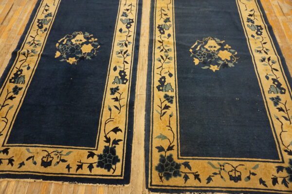 Two dark blue runners with gold floral borders are positioned side-by-side on light wood flooring.