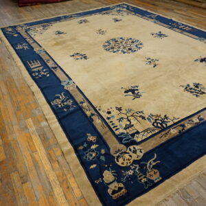 Cream rug with scattered blue floral motifs and a wide, indigo border displayed on rustic wood floors.